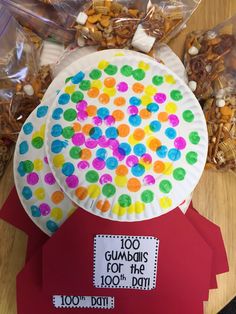 a paper plate with gummy dots on it next to some bags of candy and candies