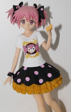 a doll with pink hair wearing a black and white polka dot skirt holding a banana