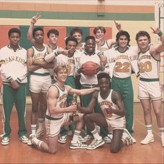 a group of young men standing next to each other on a basketball court