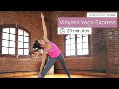 a woman is doing yoga in an empty room with brick walls and windows on the wall