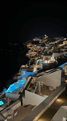 an aerial view of the rooftops and pool area at night, with lights on