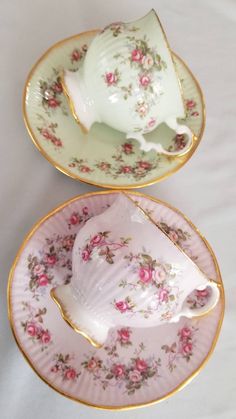 two tea cups and saucers with pink flowers on them