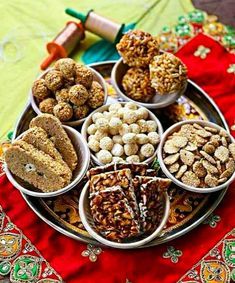 a tray filled with lots of different types of food on top of a table cloth