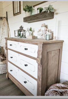 an old dresser is painted white and decorated with greenery, candles and other things