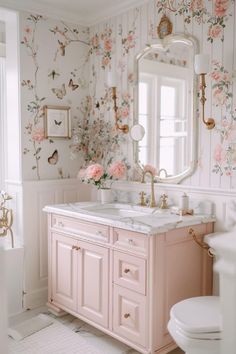 a bathroom with pink flowers on the wall and white vanity, gold faucet