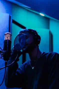 a man with headphones on singing into a microphone