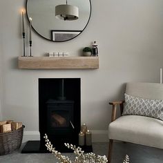 a living room with a chair, fireplace and mirror on the wall next to it