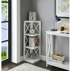 a white book shelf with books on it and a clock in the corner near a window