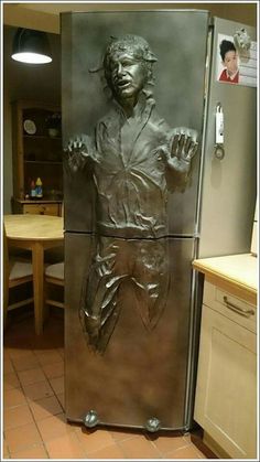 a refrigerator that has a statue of a man on it