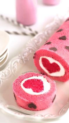 there is a pink cake roll with hearts on it and two slices cut out to show the inside