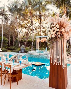 an outdoor dining area next to a swimming pool with tables and chairs set up in front of it