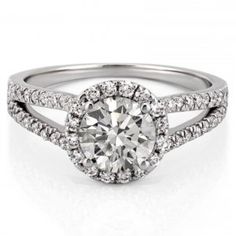 a white gold engagement ring with round diamonds on the band and an oval halo setting