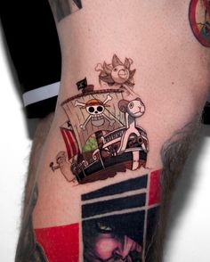 a man's leg with a pirate ship tattoo on it and an image of his face