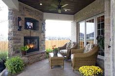 an outdoor living area with wicker furniture and fireplace