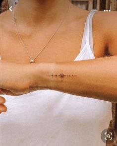 a woman with a cross tattoo on her arm