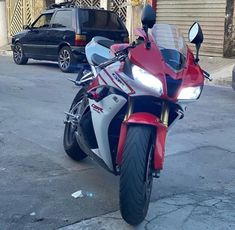 a red and white motorcycle parked on the street