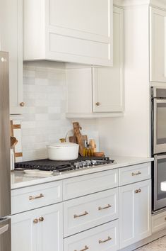 a kitchen with white cabinets and stainless steel appliances