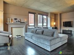 a living room filled with furniture and a fire place in the middle of a room