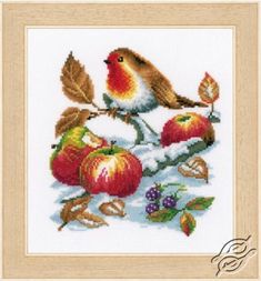 a cross stitch pattern with a bird sitting on an apple tree branch and apples in the snow