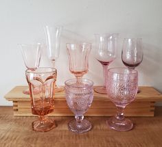 five wine glasses lined up on a wooden table