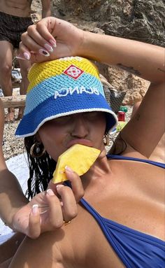 a woman eating a banana on the beach