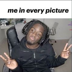 a man with dreadlocks sitting in a chair holding his hands up to the camera