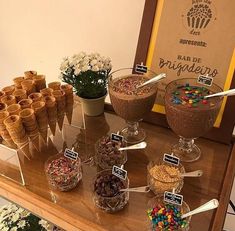 an assortment of desserts and candies displayed on a wooden table in front of a sign