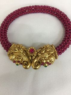 A new addition to our product line by our artisans. A beautiful piece for our traditional Indian Bride! Notice the gorgeous carving work on the twin elephant figure at the center and the red-colored beaded mesh at the base. Material: Brass and copper mix, gold plated, beads The bracelet is the same as shown in the picture and in the video. We have only one piece in this design and color and hence you get what you see in the picture. For wrist sizes 2.4- 2.6 Easily openable with a screw. Red Motif Jewelry For Rituals, Red Motifs Jewelry For Rituals, Red Jewelry With Motifs For Rituals, Red Intricate Design Temple Necklace For Festive Occasions, Red Ruby Temple Necklace With Intricate Design, Handmade Red Temple Necklace, Red Beaded Temple Necklace For Festivals, Handmade Red Temple Necklace For Festivals, Traditional Red Temple Necklace With Zari Work