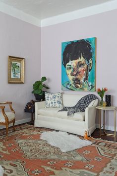 a living room filled with furniture and a painting on the wall above it's head