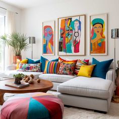 a living room filled with lots of furniture and paintings on the wall above it's couches