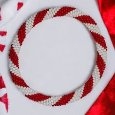 a red, white and blue beaded necklace on top of a cloth covered table