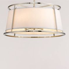 a modern chandelier hanging from the ceiling with a white shade on it's side