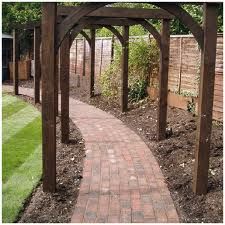 a brick path leading to a wooden gazebo