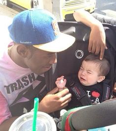 a man is holding a baby in a stroller