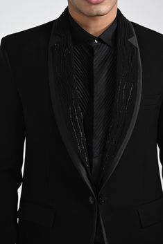 a man wearing a black suit and tie