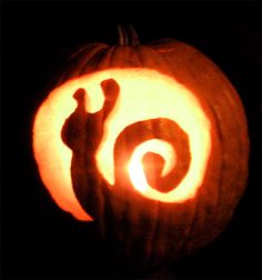 a pumpkin carved to look like a snail with its tail curled in the shape of a spiral