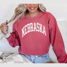 FREE SHIPPING IN THE US! No order minimum! Nebraska Sweatshirt, Nebraska Comfort Colors, Nebraska Shirt, Nebraska Shirt, Retro Nebraska Sweatshirt, Nebraska Crewneck, Nebraska Shirts ♥ The CREWNECK * This is a Comfort Colors® 1566 adult unisex crewneck sweatshirt. * 100% ring spun cotton and garment-dyed fabric, giving a soft color and texture * Size up for an oversized look. Detailed sizing information can be found in the size chart in the photos. * Printed in the USA. ♥ CARE ＊Machine wash cold Relaxed Fit Long Sleeve Tops For School Spirit, Long Sleeve Tops With Relaxed Fit For School Spirit, Relaxed Fit Crew Fan Apparel Tops, Relaxed Fit Crew Neck Fan Apparel Top, Soft-washed Long Sleeve Top For Game Day, School Spirit Soft-washed Crew Neck Top, Pre-shrunk Long Sleeve Shirt For College, Soft-washed Crew Neck Top For School Spirit, Nebraska Sweatshirt