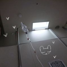 a bathroom with a glass shower stall and skylight in the ceiling, along with drawings on the floor