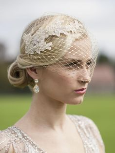 a woman in a wedding dress wearing a birdcage veil