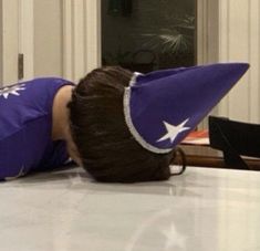 a woman laying on top of a table with an umbrella over her head in front of a door