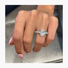 a woman's hand with a diamond ring on her left hand and the other hand holding an engagement ring