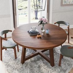 a round table with chairs around it in front of a window and rug on the floor