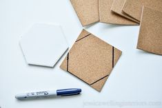 several pieces of brown paper are laid out on a white surface with a blue marker