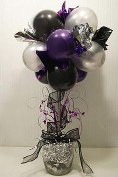 a vase filled with lots of balloons on top of a table