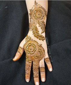 a woman's hand with henna tattoos on it