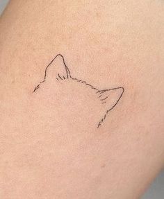 a small tattoo of a cat's head on the back of a woman's thigh