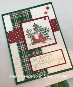 a christmas card with a house and tree on it, surrounded by green plaid paper