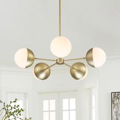 a living room filled with furniture and a light fixture hanging over the top of it