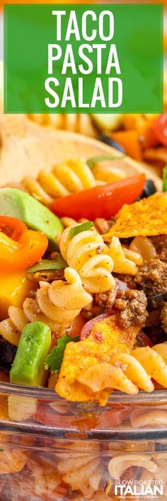 pasta salad in a glass bowl with the words taco pasta salad