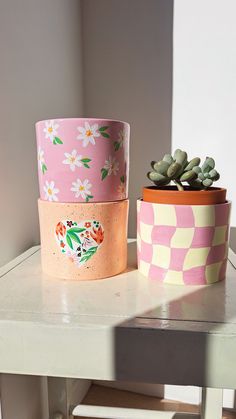 two flower pots sitting on top of a table